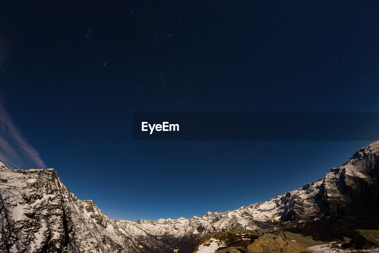 LOW ANGLE VIEW OF MOON OVER LANDSCAPE