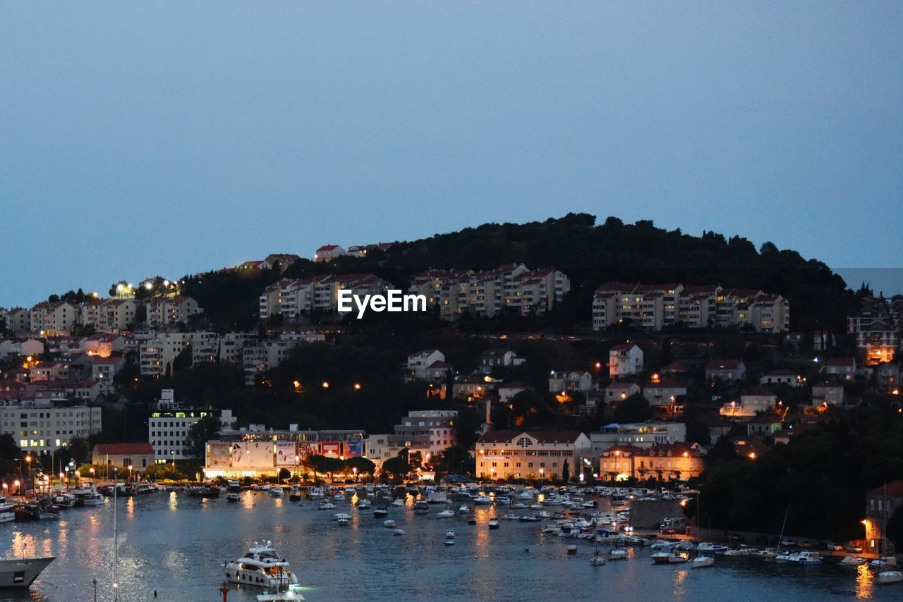 VIEW OF ILLUMINATED CITYSCAPE AGAINST CLEAR SKY