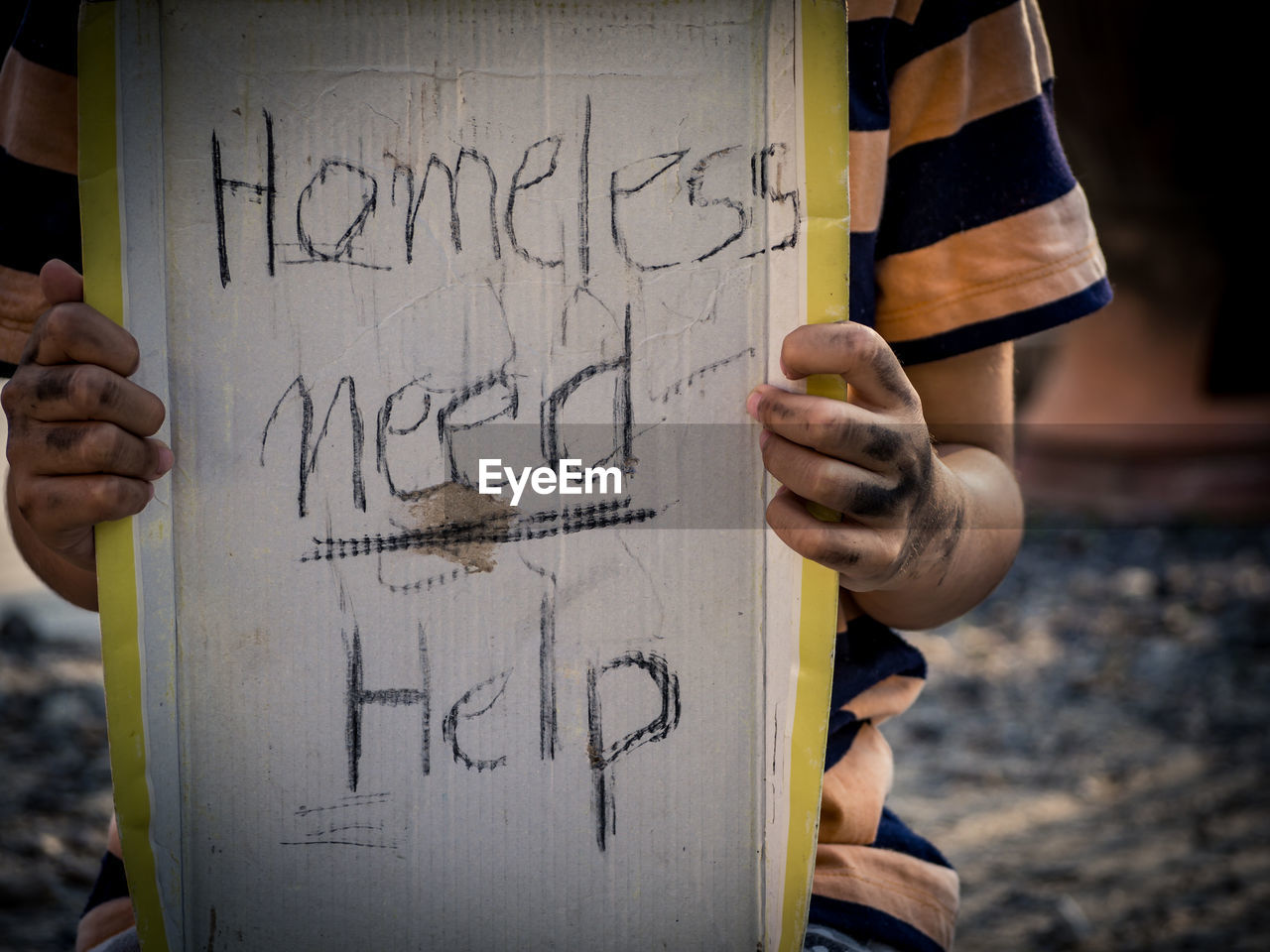 Close-up of beggar holding text