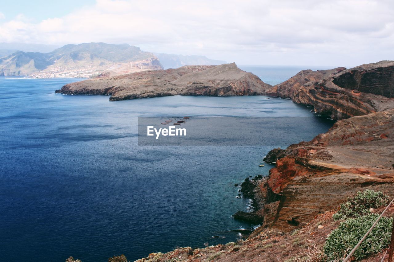 Scenic view of sea and mountains against sky