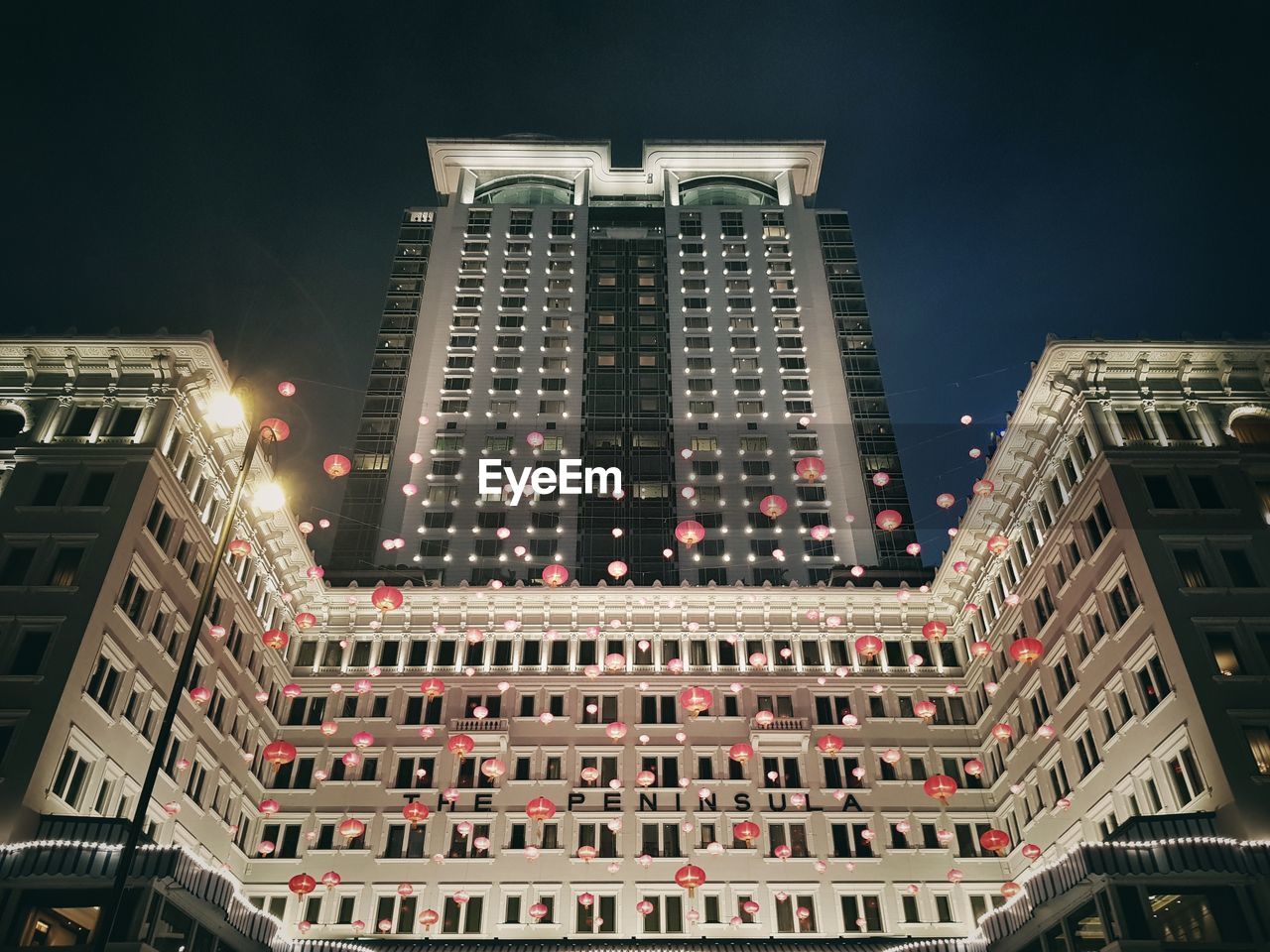 Low angle view of illuminated buildings against sky at night