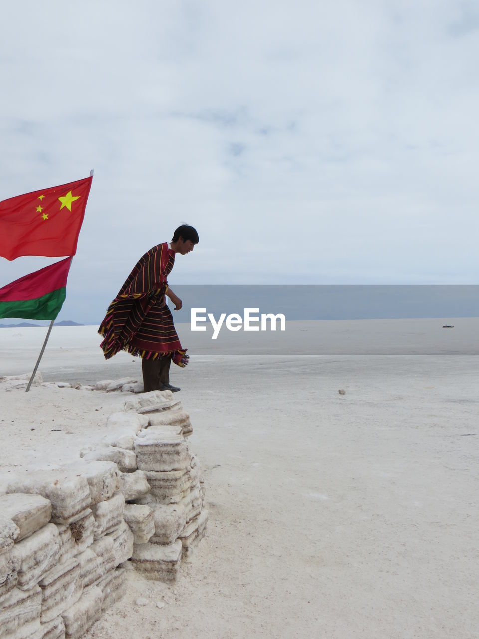 flag, sea, beach, sand, patriotism, day, outdoors, nature, real people, horizon over water, standing, water, sky, beauty in nature, one person