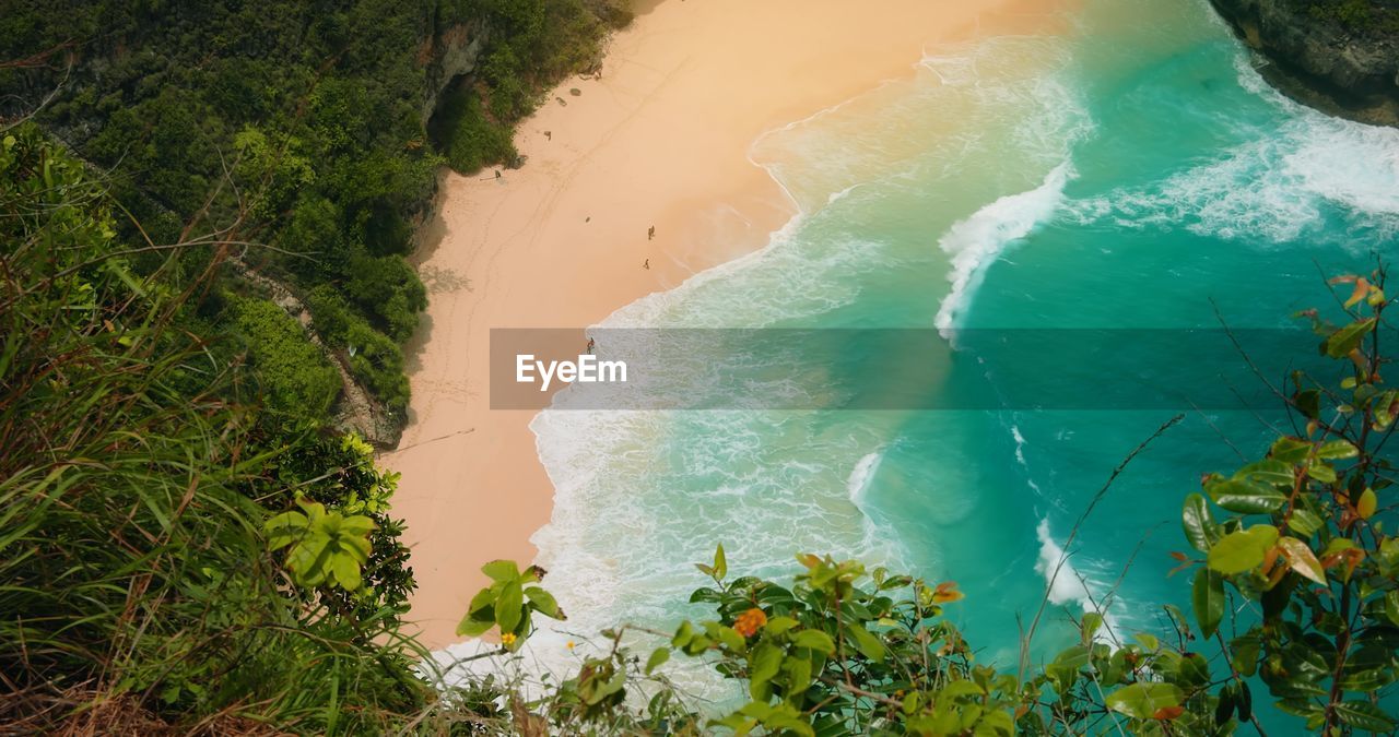 Ocean on golden sandy kelingking beach at sunset in bali nusa penida indonesia. tropical landscape.