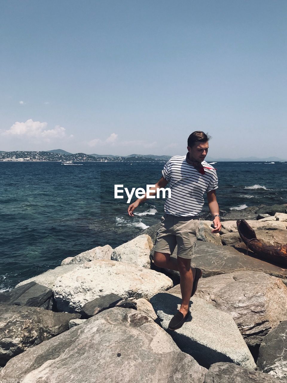 Man standing on rock against sea at beach