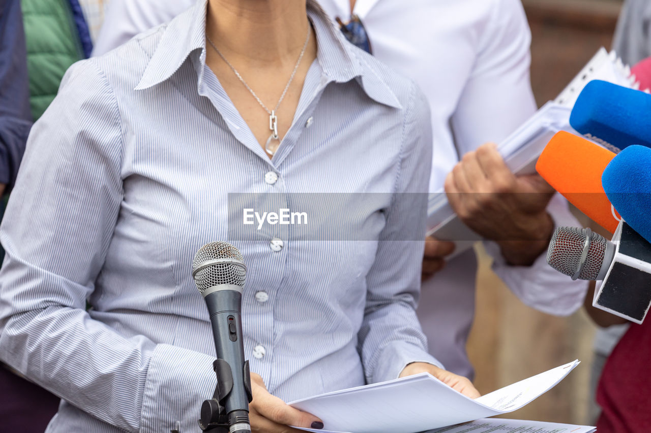 Female whistleblower is giving a speech at news conference or media event