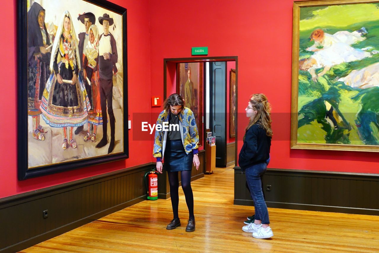 WOMEN STANDING IN MUSEUM