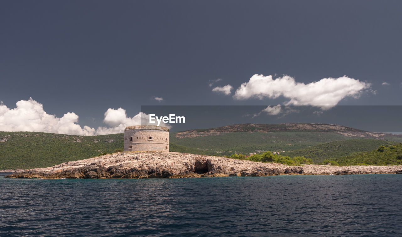 Building by sea against sky