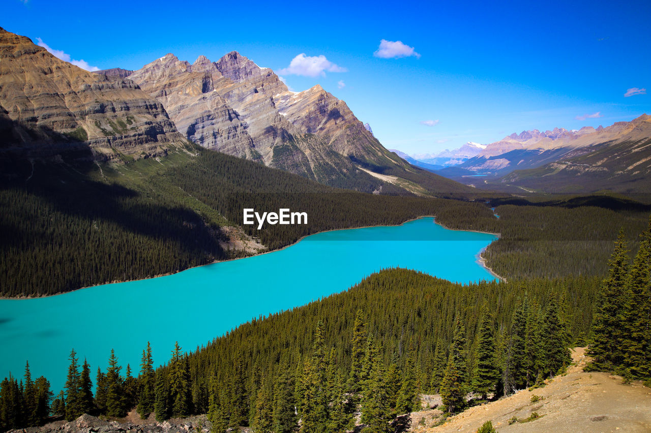 Scenic view of lake and mountains against blue sky