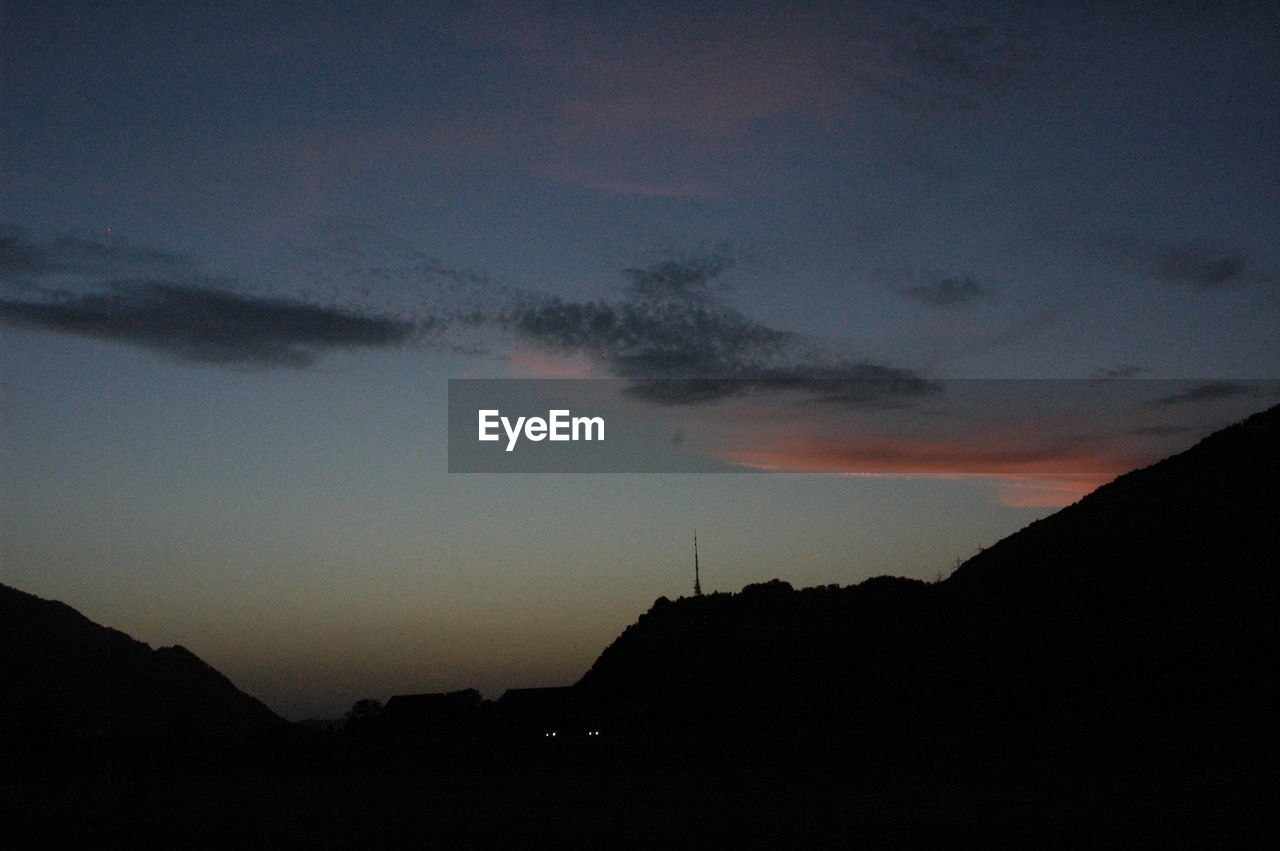 SCENIC VIEW OF MOUNTAINS AT SUNSET