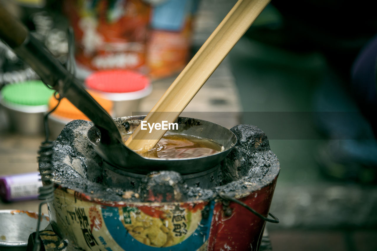 Close up of cooking oil in spoon on stove