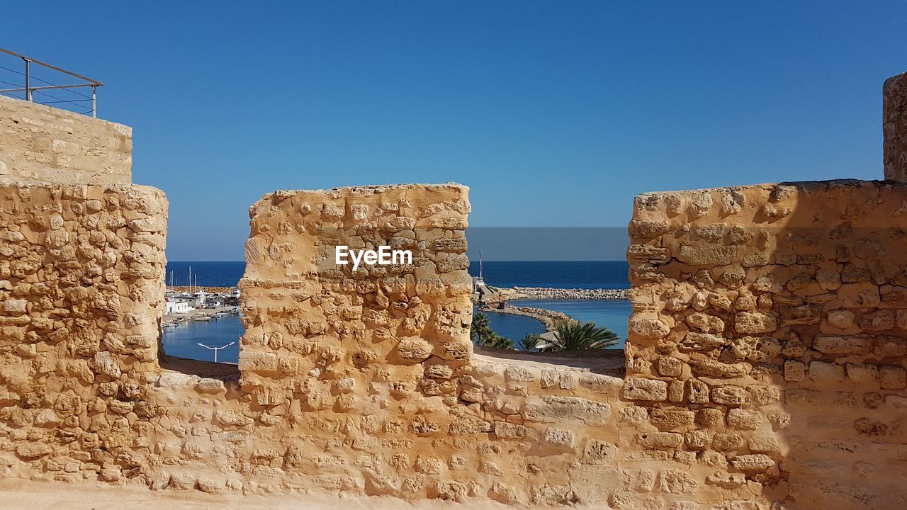 BUILT STRUCTURE AGAINST CLEAR BLUE SKY AND WALL