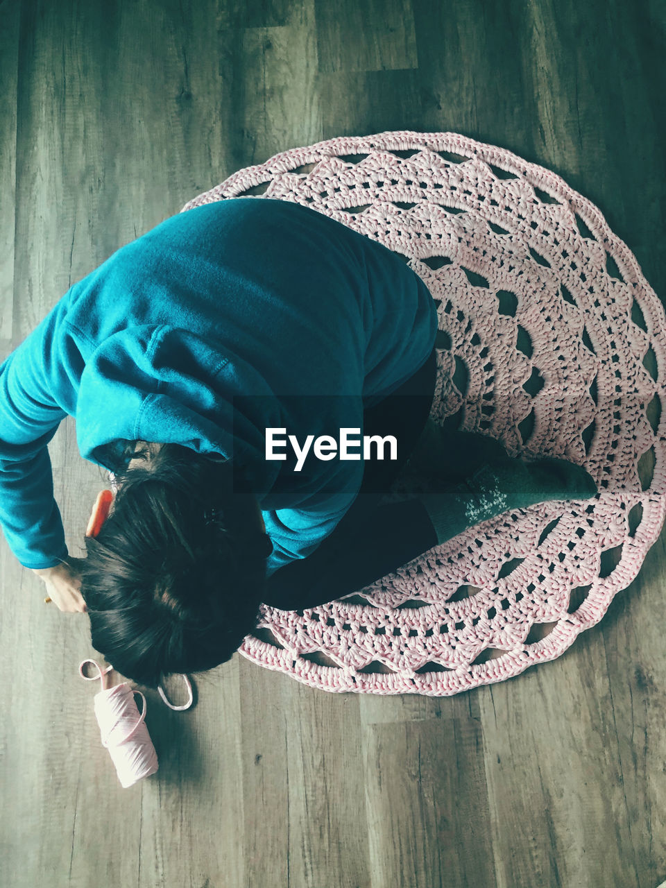 High angle view of boy kneeling on wooden floor