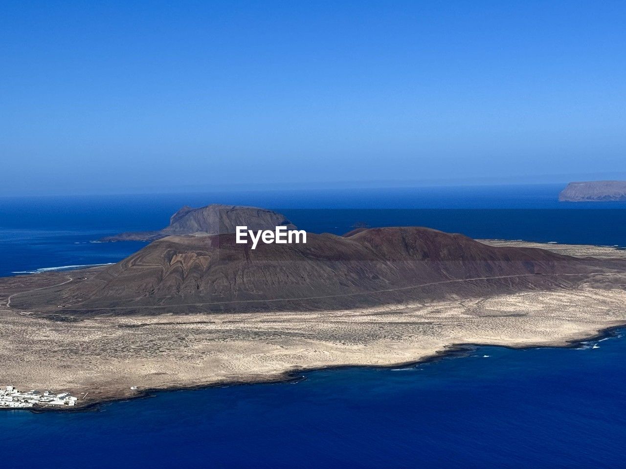 scenic view of sea and mountains against clear blue sky