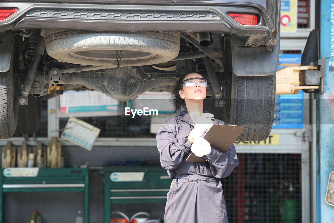 Man working with woman standing in car