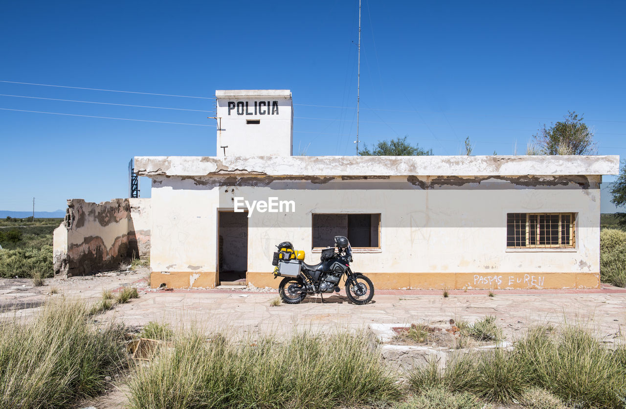 Touring motorbike parked in front of abandoned police station