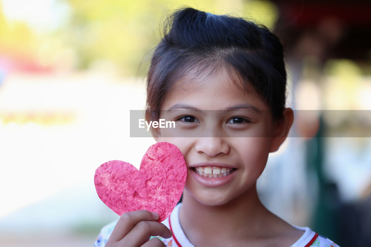 close-up of cute girl holding heart shape