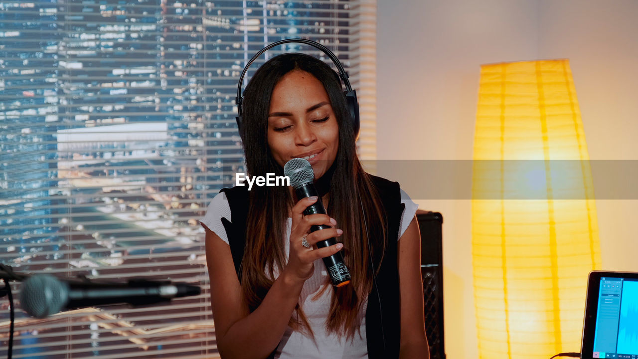 Woman singing while sitting at home