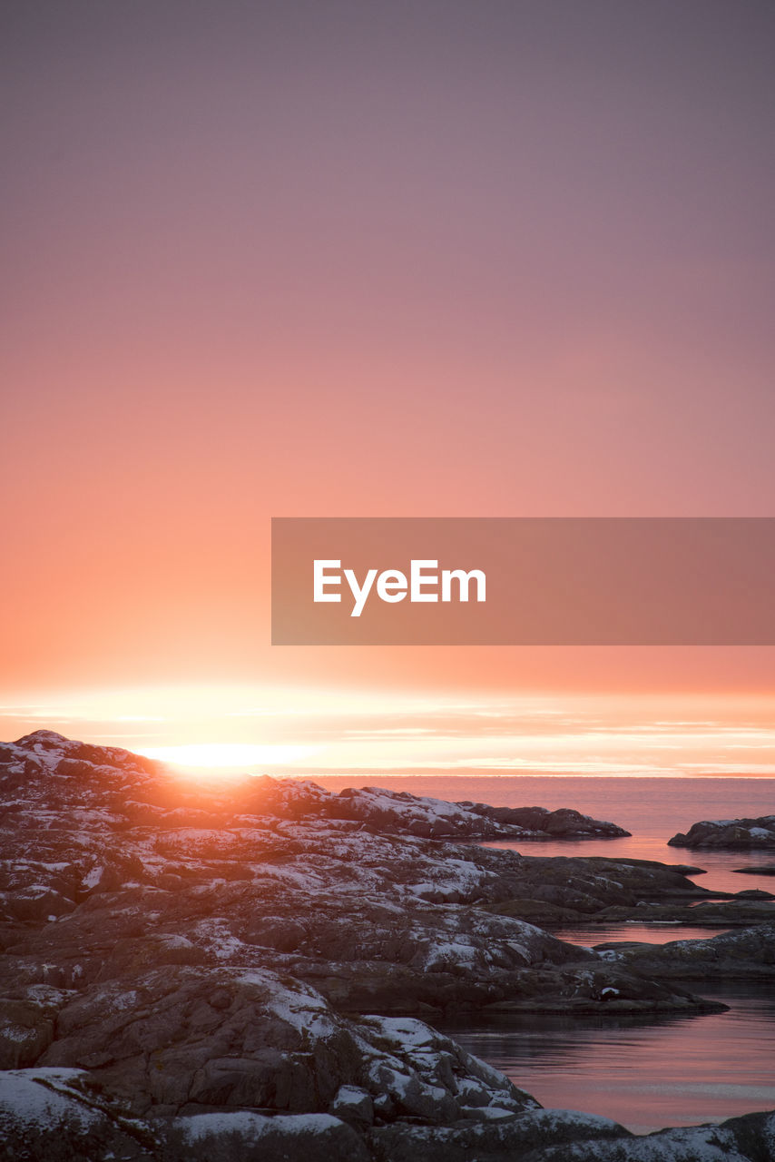 Scenic view of snow covered landscape against sky during sunset