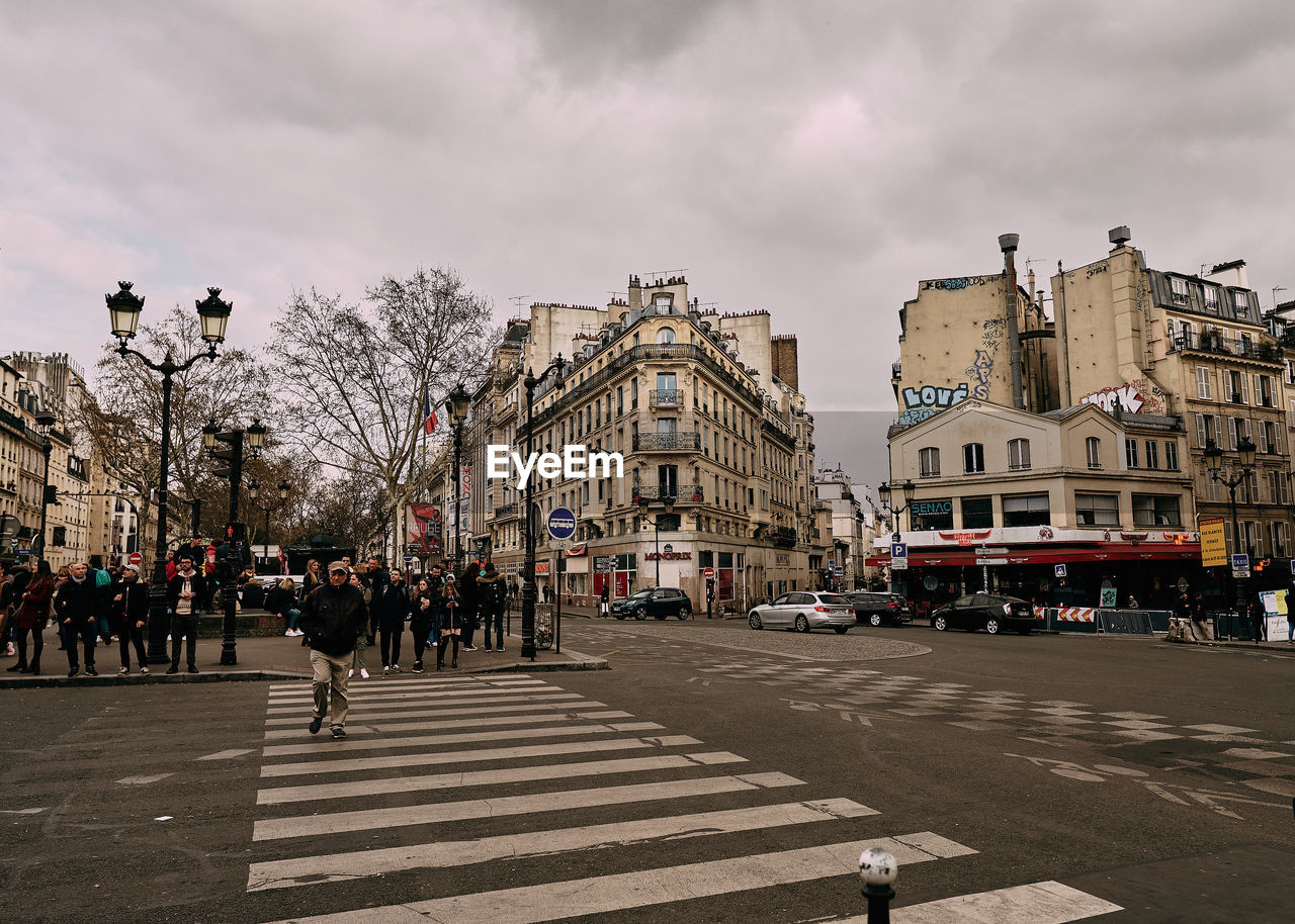 People walking on street against sky