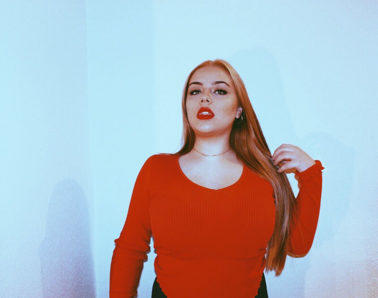 Portrait of woman standing against wall at home