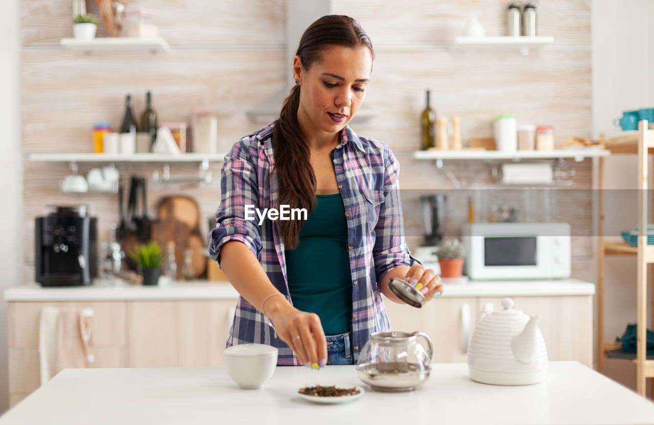 portrait of young woman sitting on table in cafe