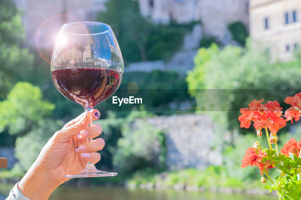 A woman hand holding a glass of red wine