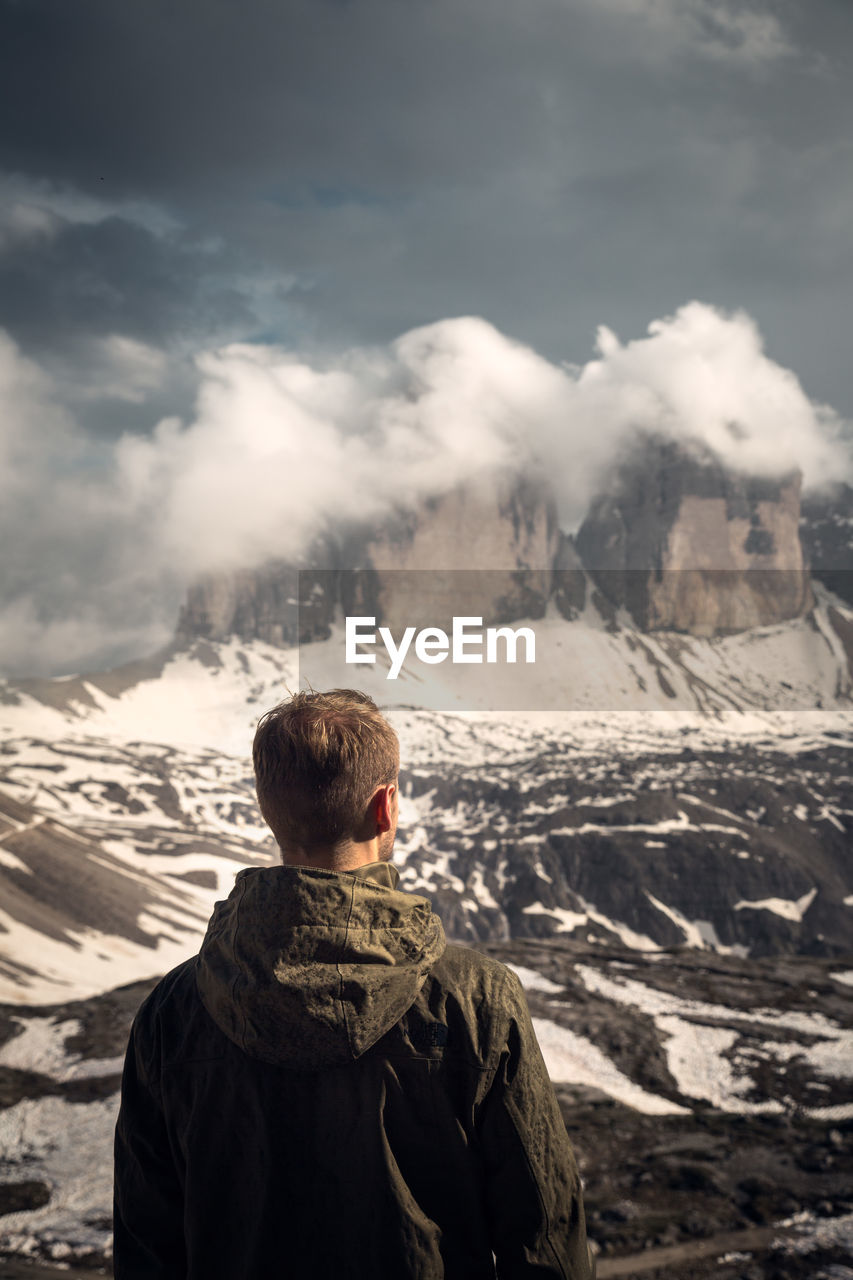 Rear view of man against snowcapped mountains and sky