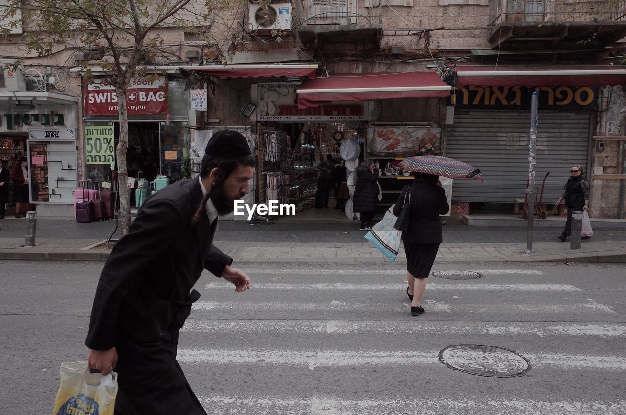 SIDE VIEW OF MAN WALKING ON ROAD