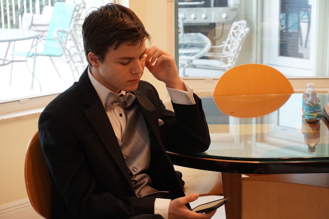 Young man using mobile phone while sitting in cafe