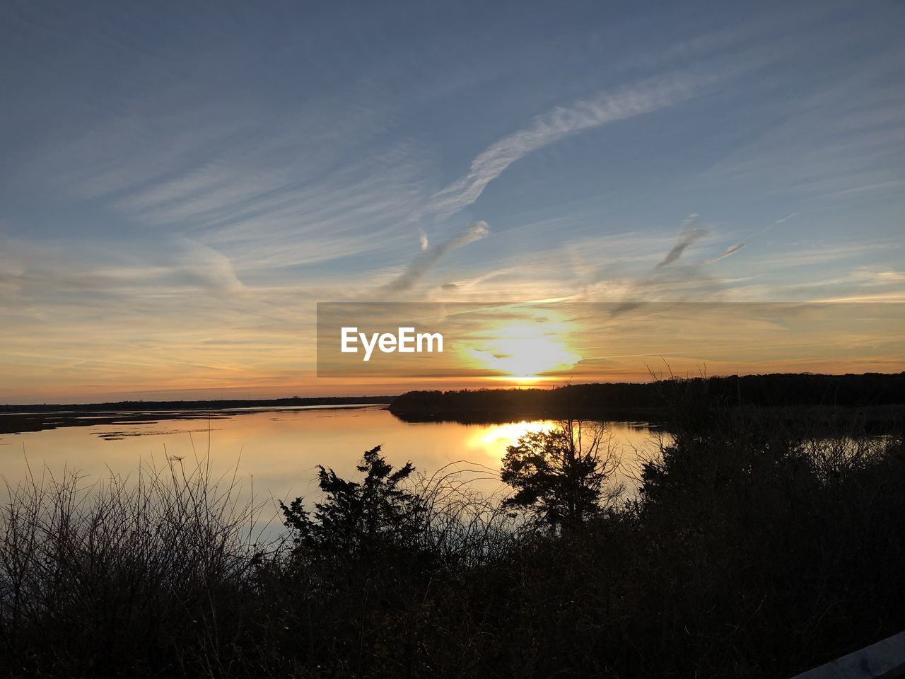 Scenic view of lake against sky during sunset