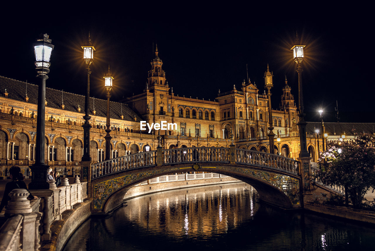 Bridge over canal in city at night