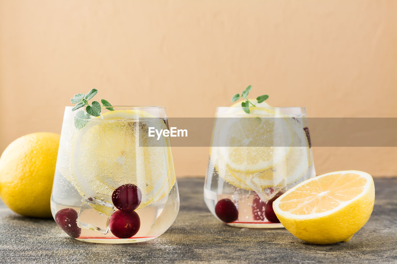 Summer refreshing cold cocktail with lemon and cherry - hard seltzer in glasses on the table