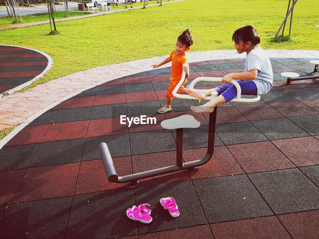 Full length of siblings playing at playground