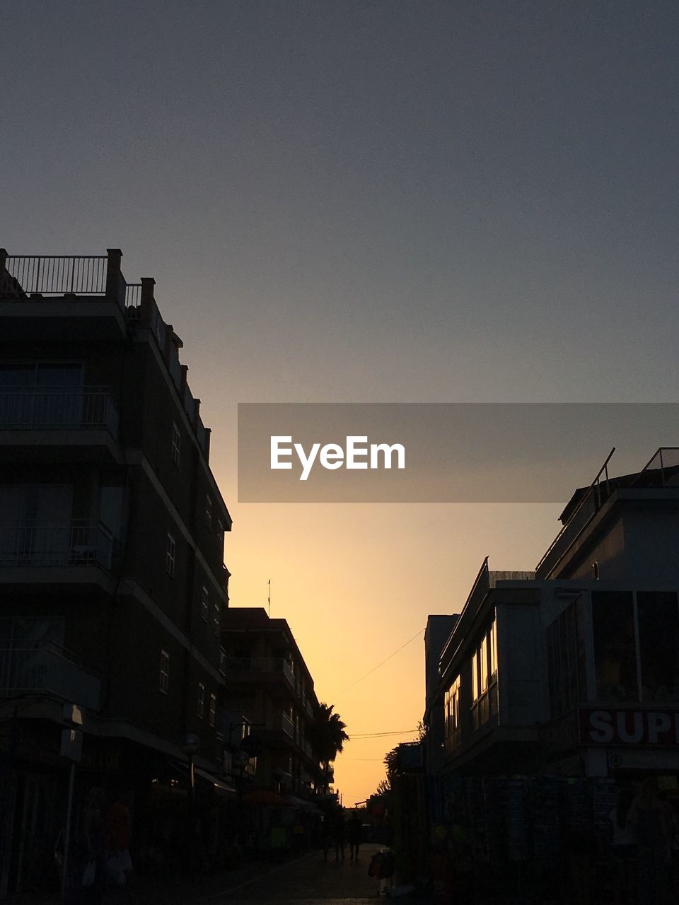 Buildings against clear sky at sunset