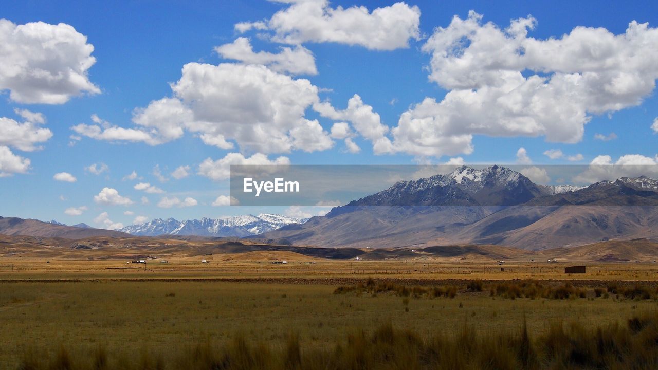 Scenic view of field and mountains against sky