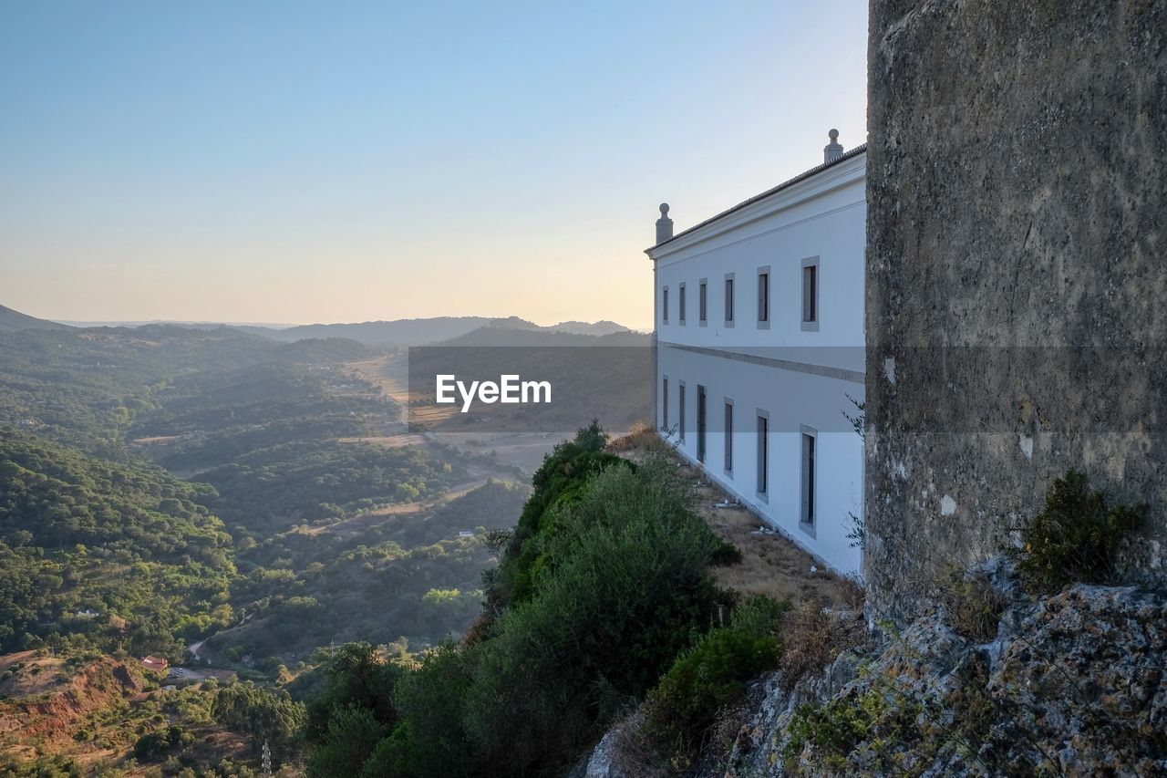 Buildings on mountain against clear sky