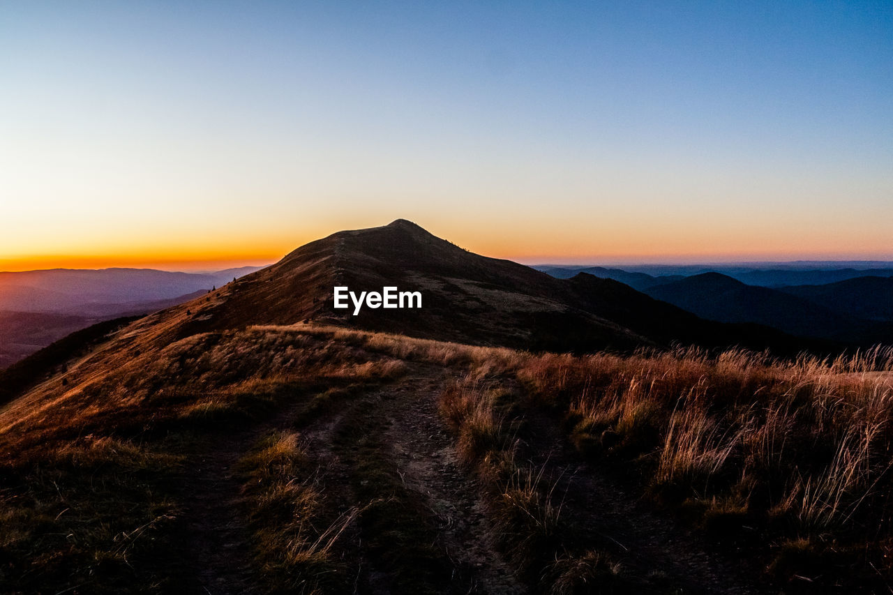 SCENIC VIEW OF MOUNTAIN AGAINST CLEAR SKY DURING SUNSET