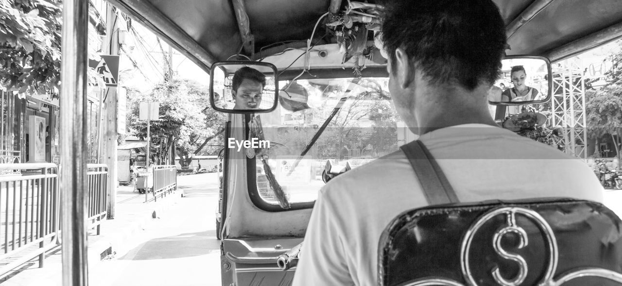 REAR VIEW OF MAN IN BUS