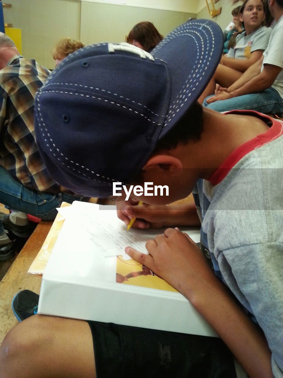 Boy wearing cap studying in classroom
