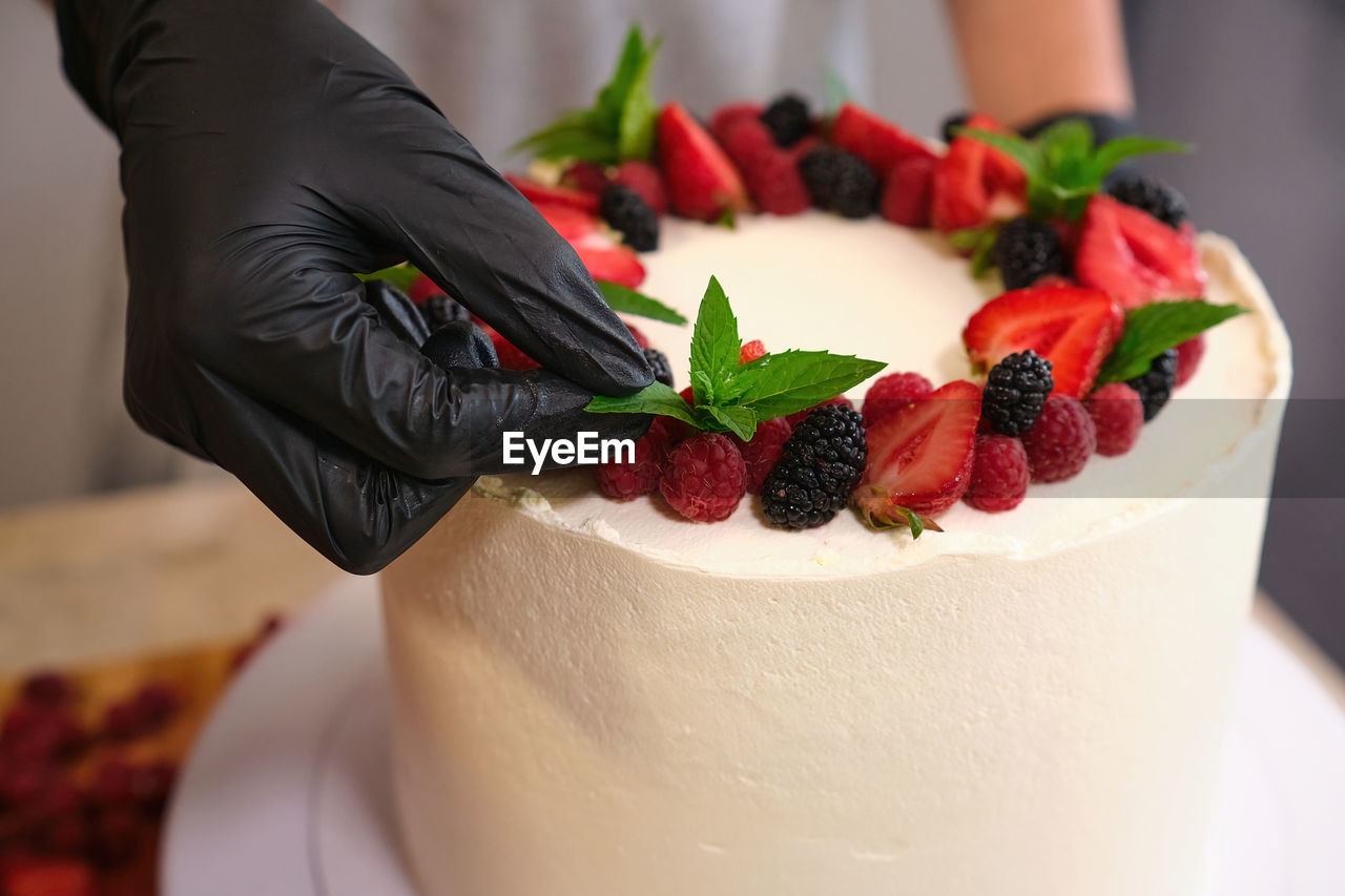 cropped hand of woman holding cake