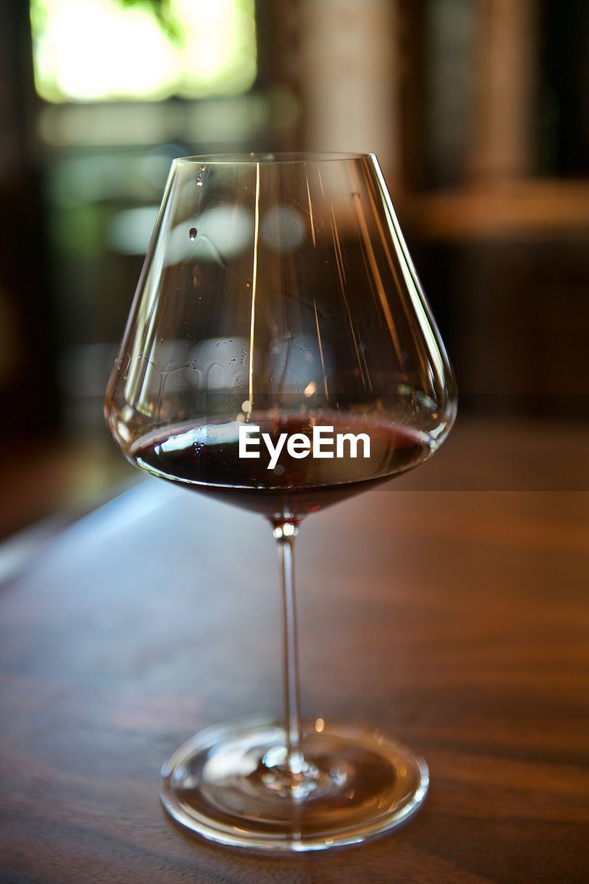 CLOSE-UP OF WINE IN WINEGLASS ON TABLE