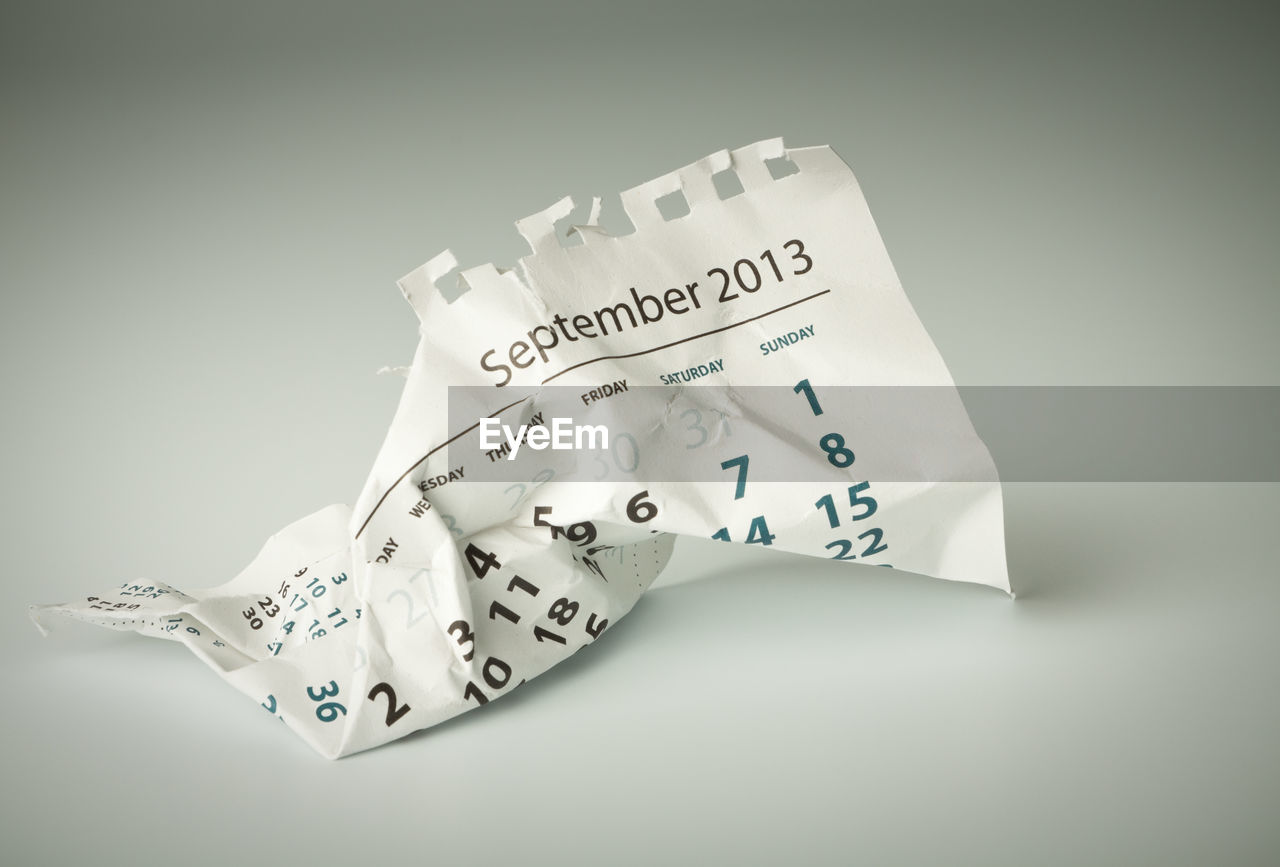 High angle view of crumpled calendar on white background