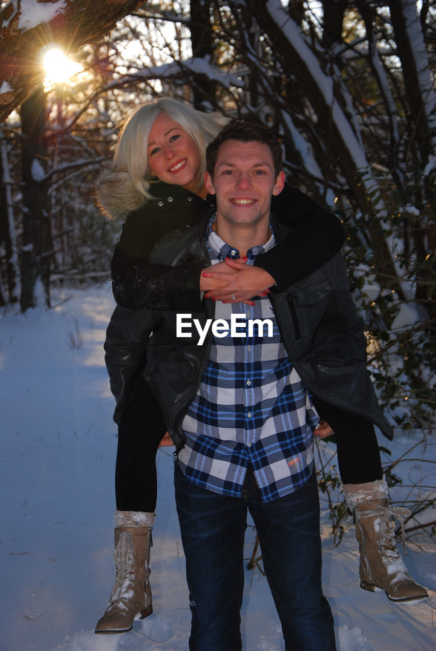 Portrait of happy young couple in snow