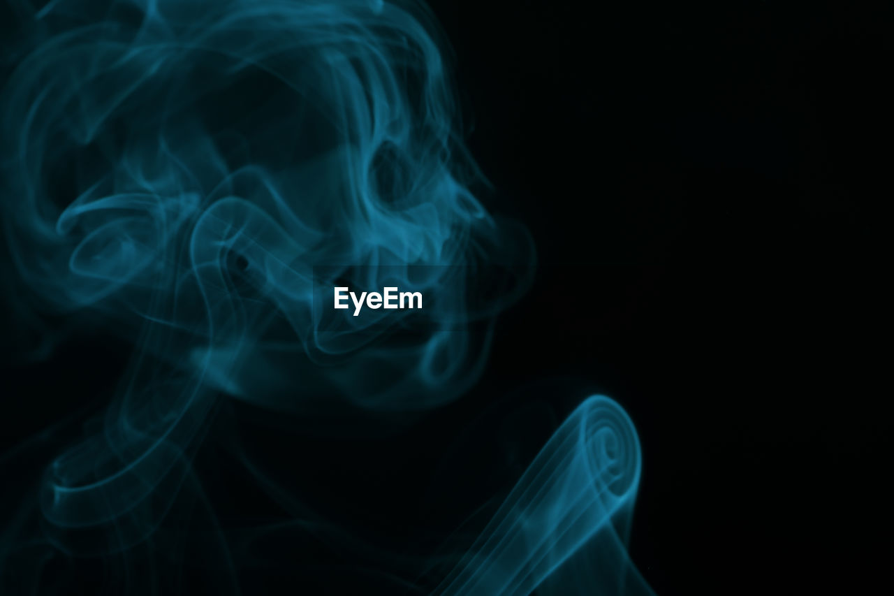Close-up of abstract smoke fog against black background