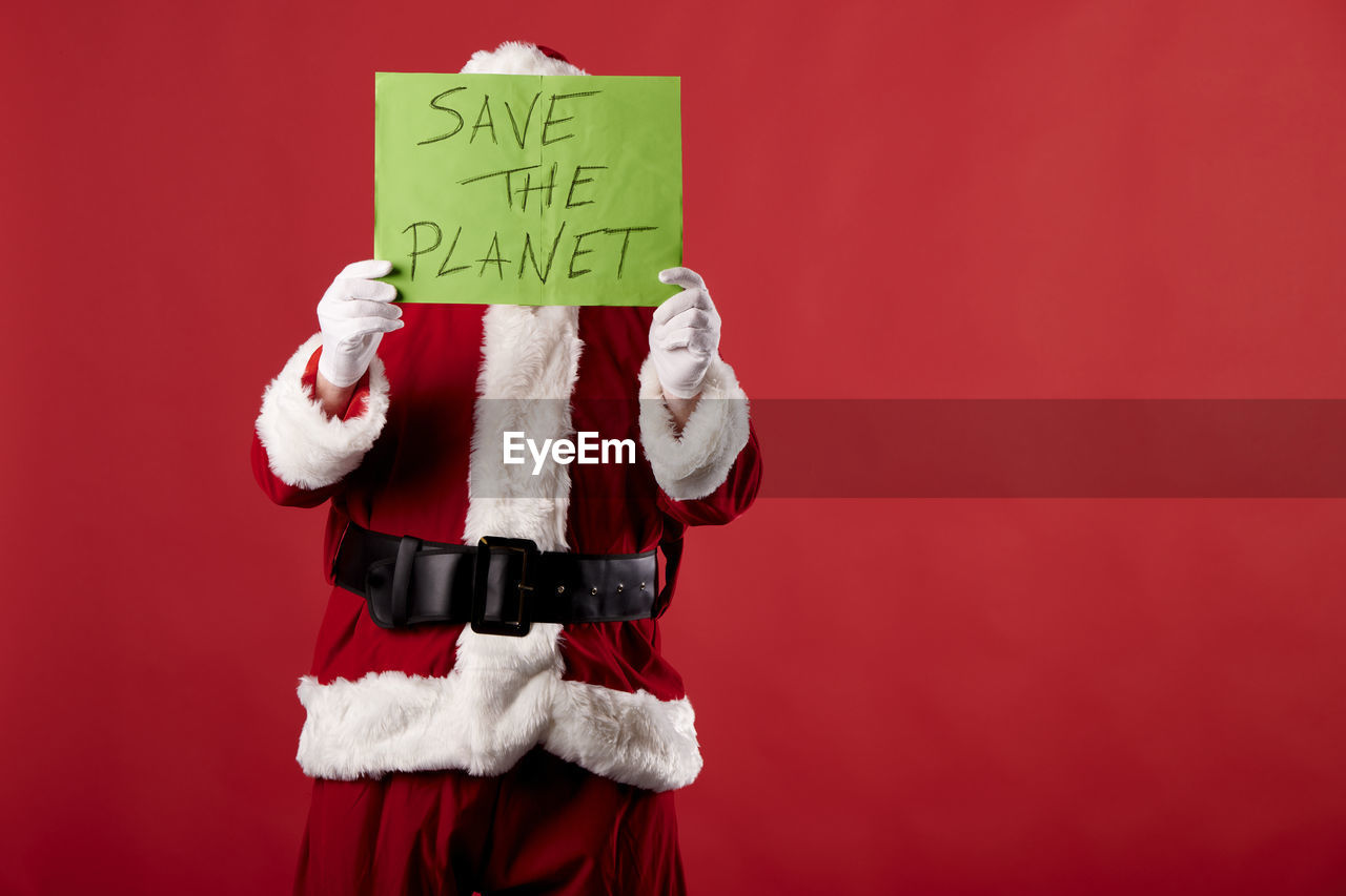 Santa claus with a save the planet poster on red background