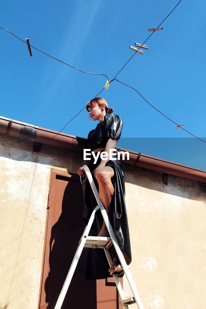 Low angle view of woman on the ladder