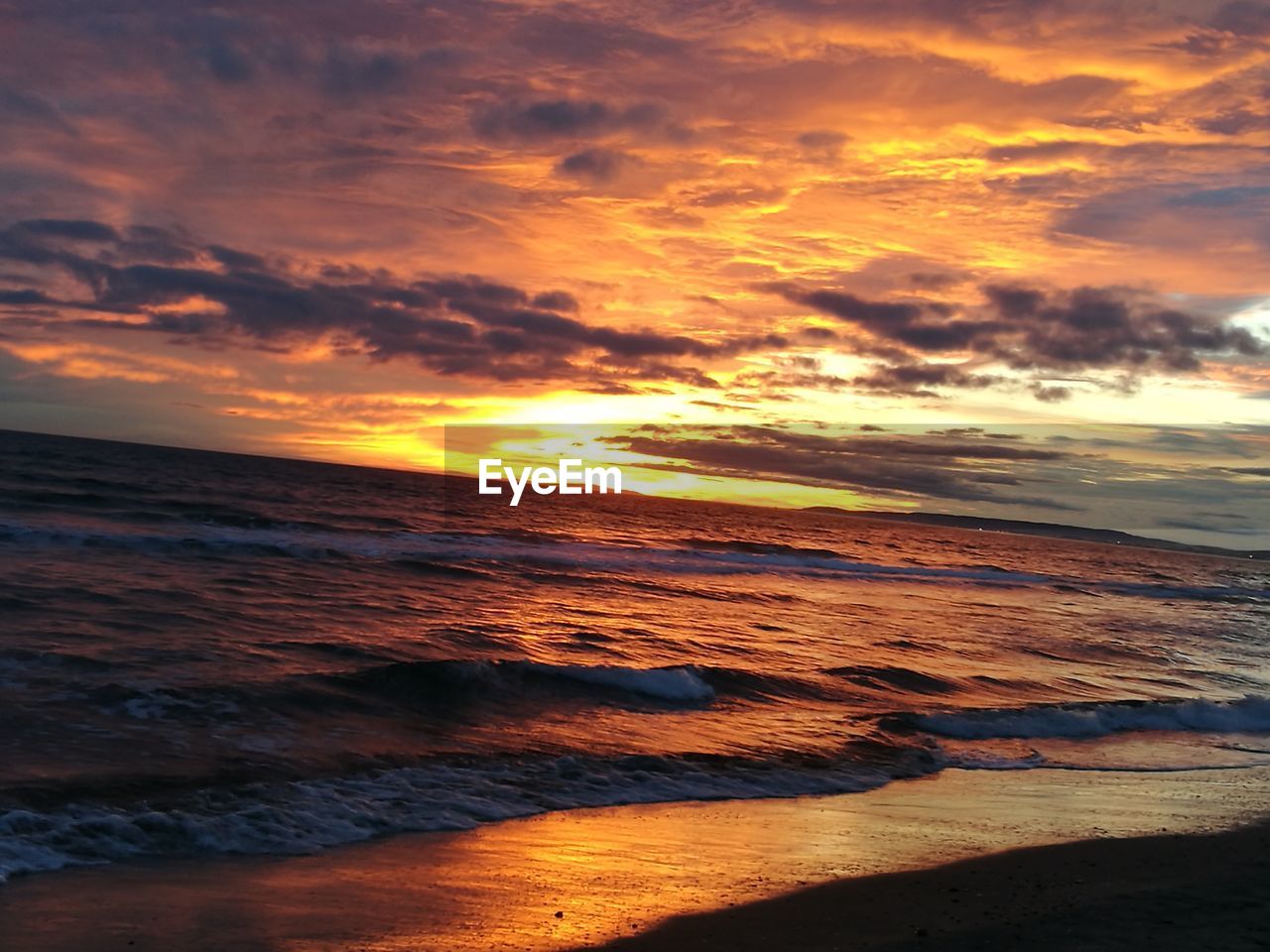 SCENIC VIEW OF BEACH AGAINST CLOUDY SKY