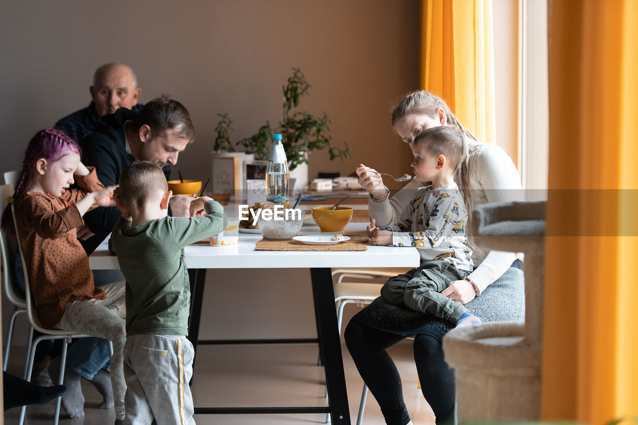 Multi generation family eating meal around kitchen table