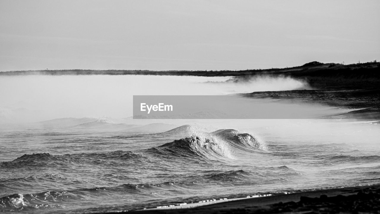 SCENIC VIEW OF WAVES BREAKING AGAINST SKY