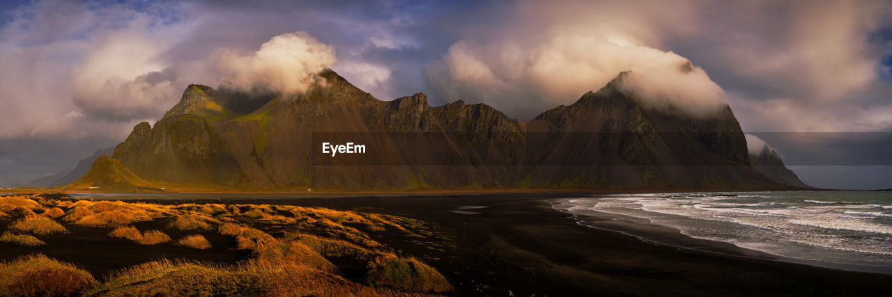 Panoramic view of sea and mountains against sky during sunset